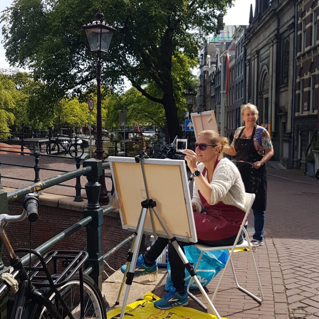 Mensen schilderend aan een gracht